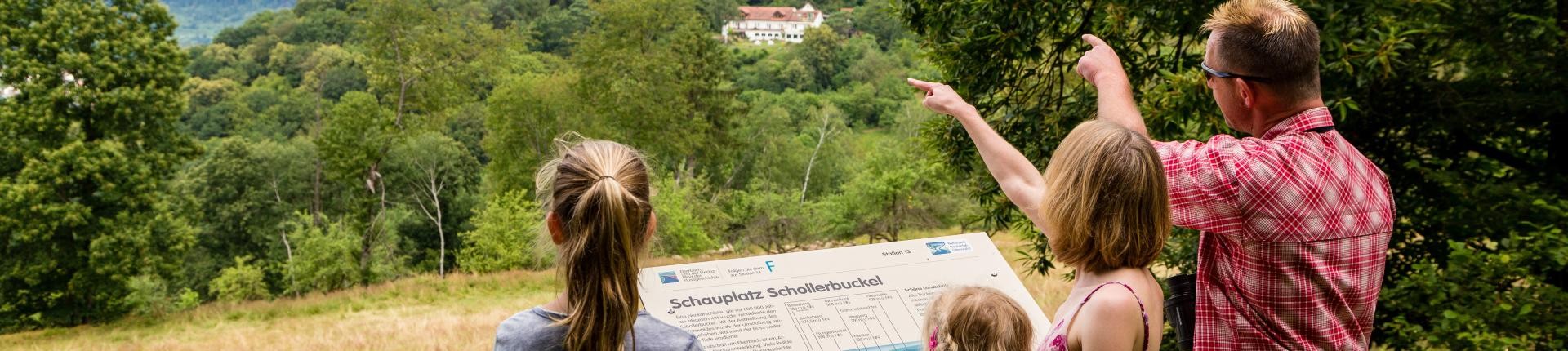 Wandergruppe im Wald, Foto: Andreas Held Wandergruppe auf Waldweg, Personen studieren eine Wanderkarte